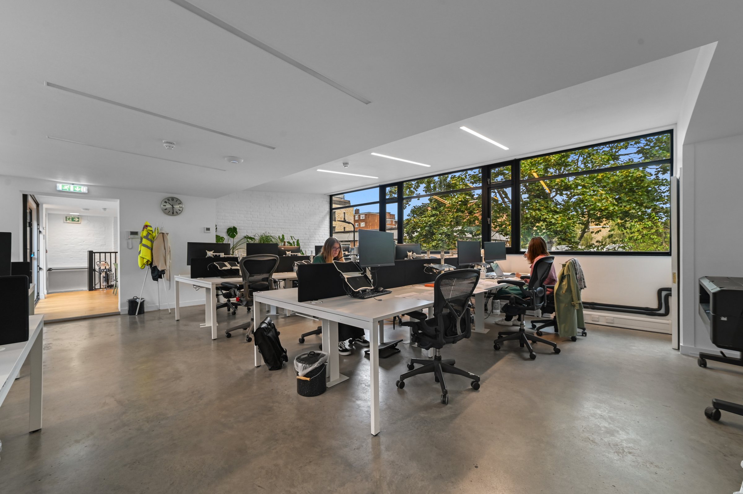 First-floor open-plan office with desks beside the windows